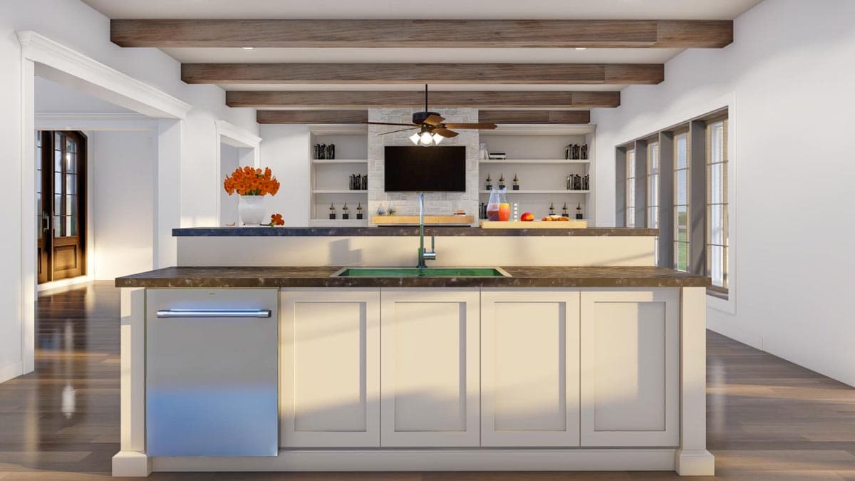 Kitchen island with sink, dishwasher, and built-in shelving; exposed wood beams on ceiling.