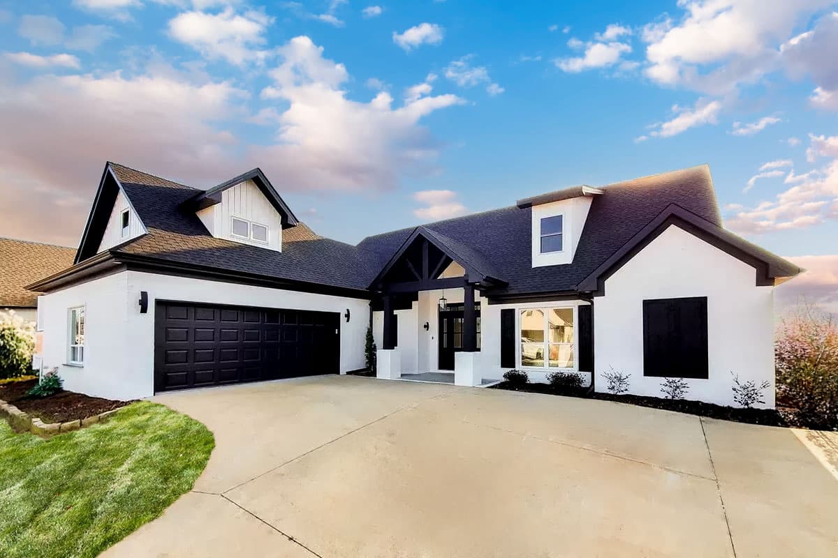 House plan exterior. Modern farmhouse style with gabled roof, dormers, and attached garage. Features a covered entry and decorative shutters.