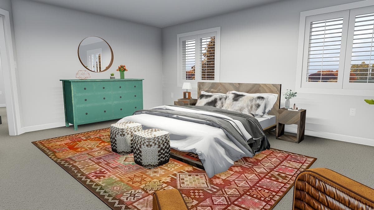 Bedroom with king size bed, chevron headboard, two windows with shutters, teal dresser, and patterned rug.