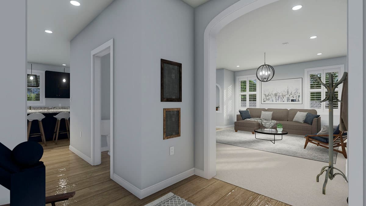 Interior view showing an open layout with a kitchen, living room with sectional sofa, and entry hall.
