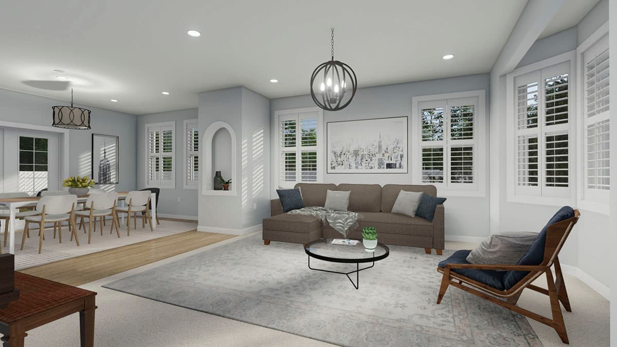 Open-concept living and dining area with sectional sofa, coffee table, dining table with chairs, and large windows with shutters.