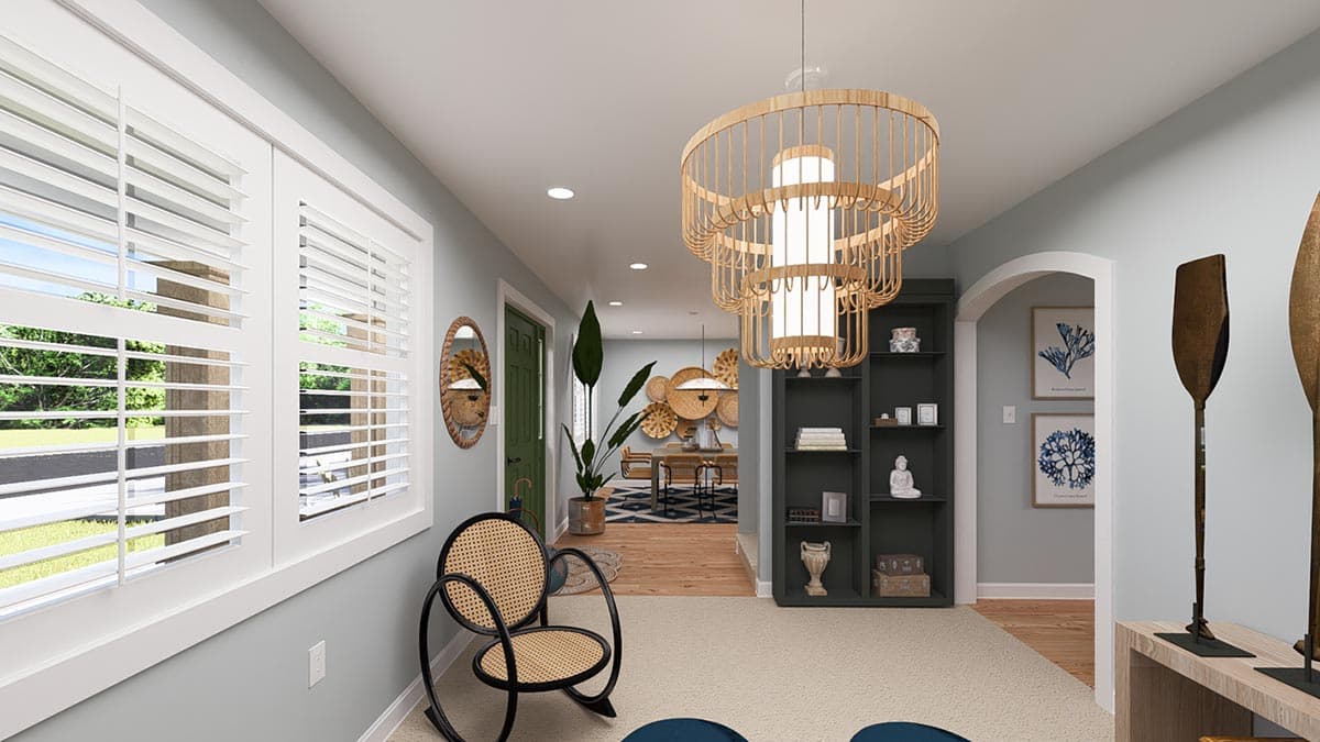 Interior view of entryway with shuttered windows, cane chair, shelving unit, and open doorway to dining area.