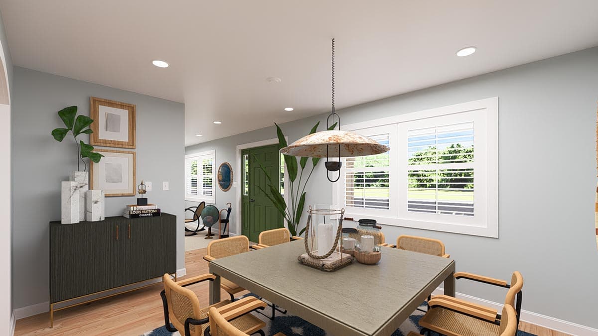Dining room with table, chairs, buffet, green door, and large windows with shutters.