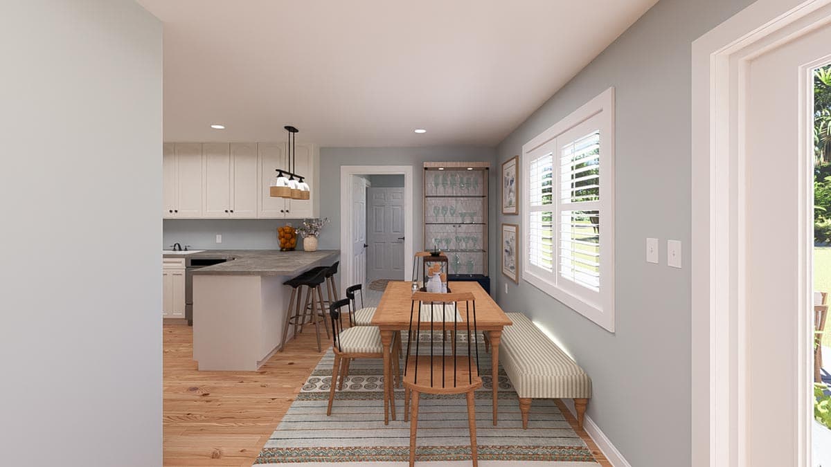 Dining area and kitchen with island, white cabinets, pendant lights, wood dining table, bench seating, and plantation shutters.