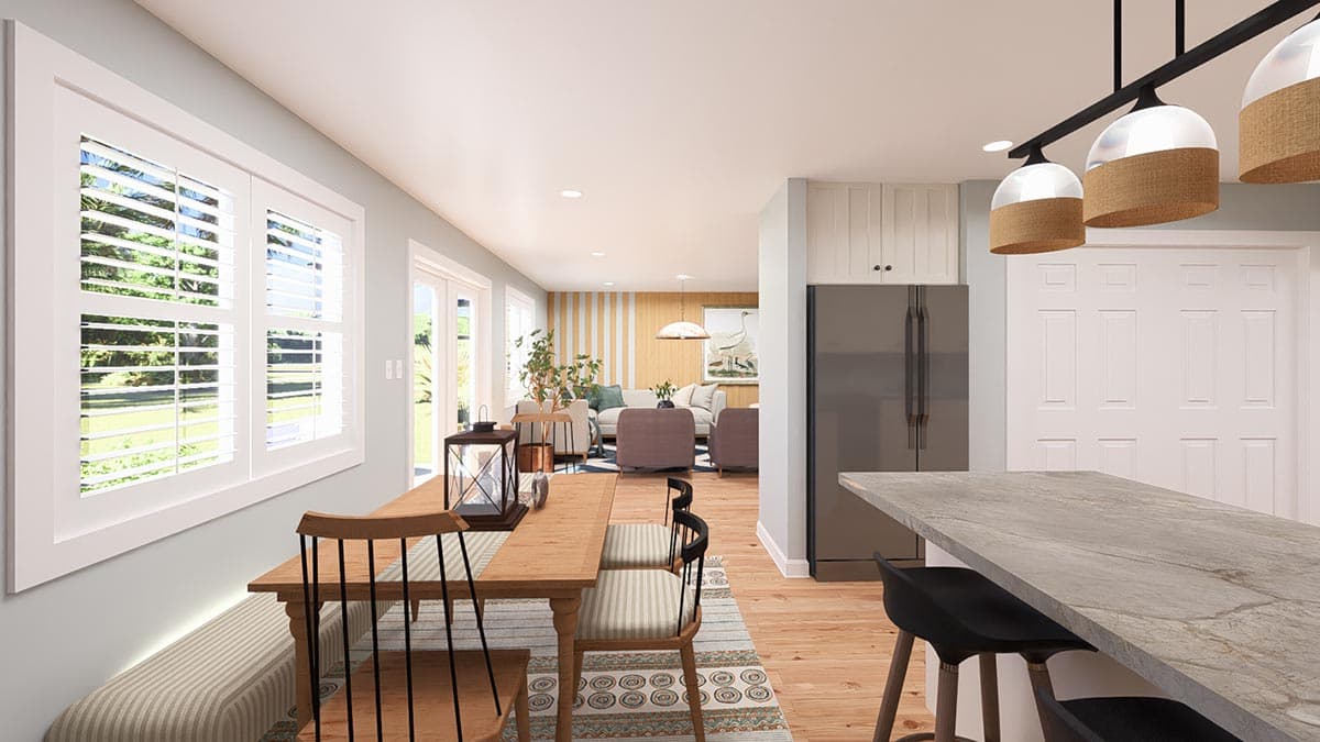 Open-concept dining area and kitchen with breakfast nook, island, and adjoining living room.