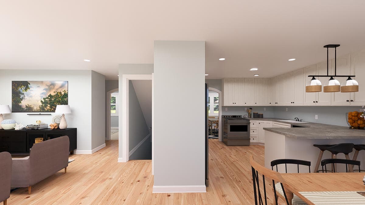 Open concept living area and kitchen with white cabinets, large island, and view of stairs.