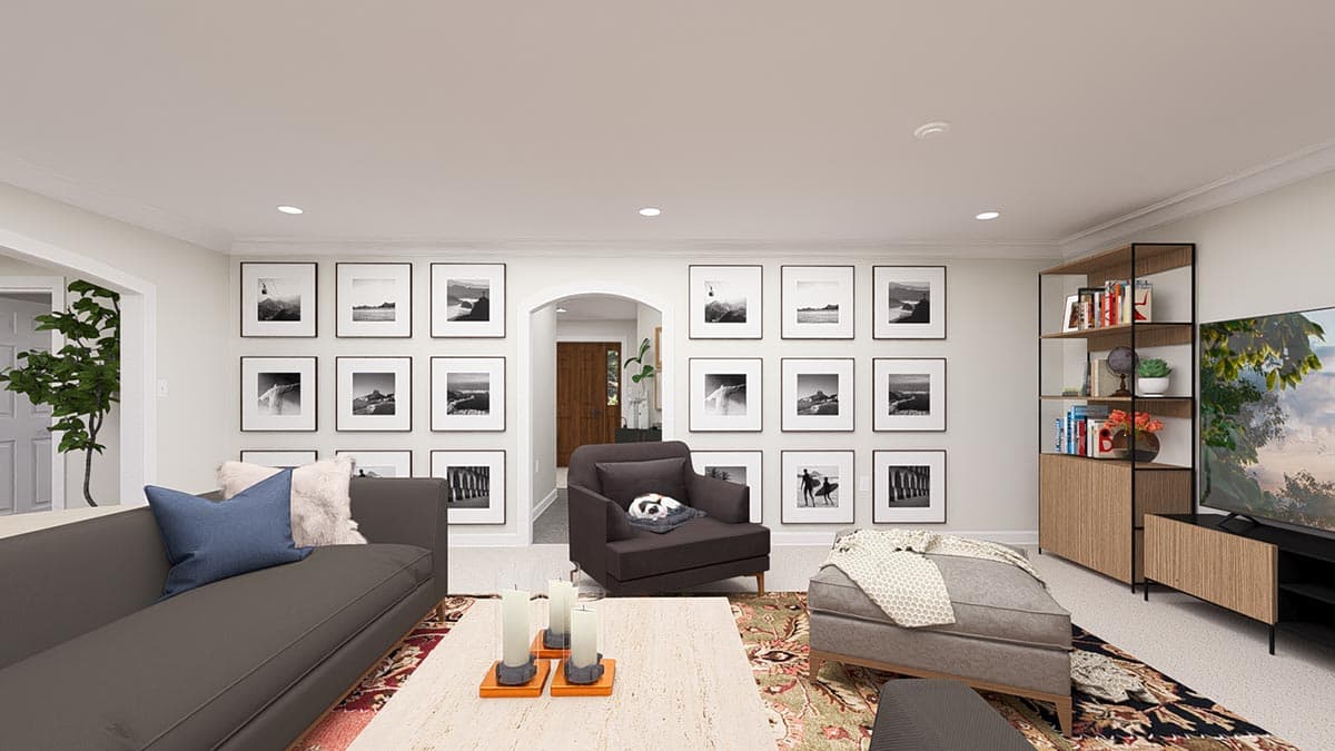Living room with gray sofa, armchair with dog, gallery wall of black and white photos, shelving unit, and television.