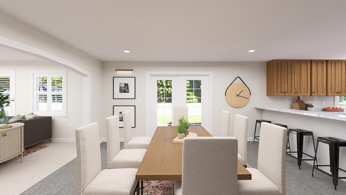 Dining area with wooden table and chairs, view of kitchen with island, bar stools, and wood cabinetry.