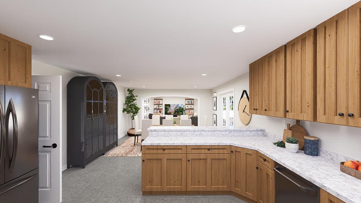 Kitchen with light wood cabinetry, marble countertops, and an open view to a dining and living area.