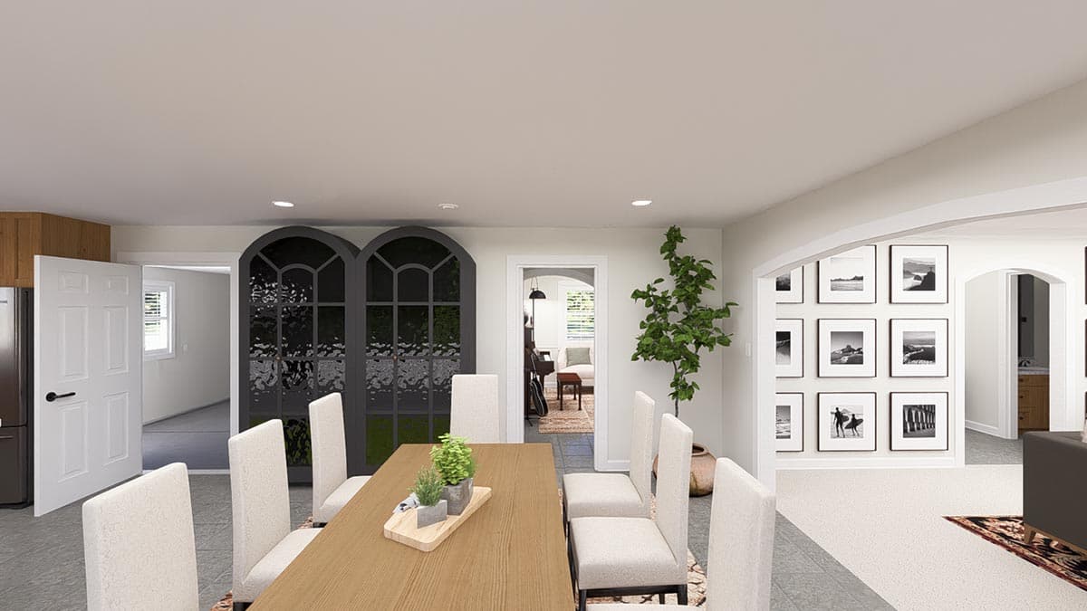 Dining area with arched windows, a wooden table, and chairs. Adjacent living space with artwork.