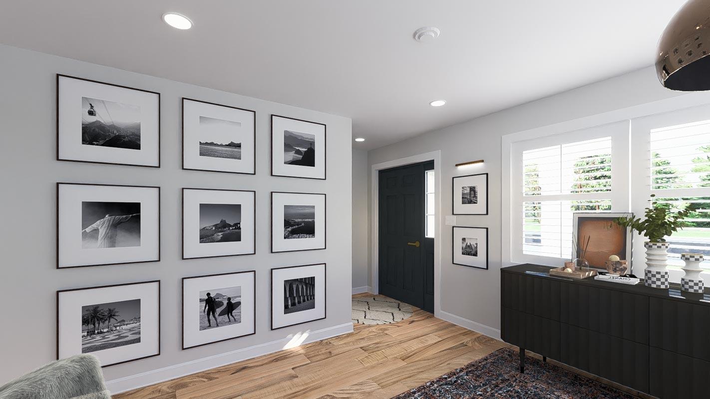 Interior hallway with nine framed black and white photographs, a dark wood door, and a black credenza with decorative objects.