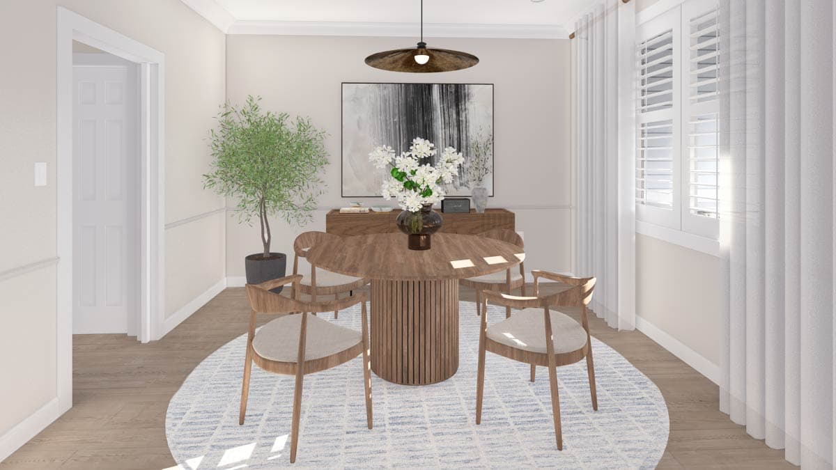 Dining room with round pedestal table, four chairs, sideboard, abstract art, plant, and window with shutters and curtains.