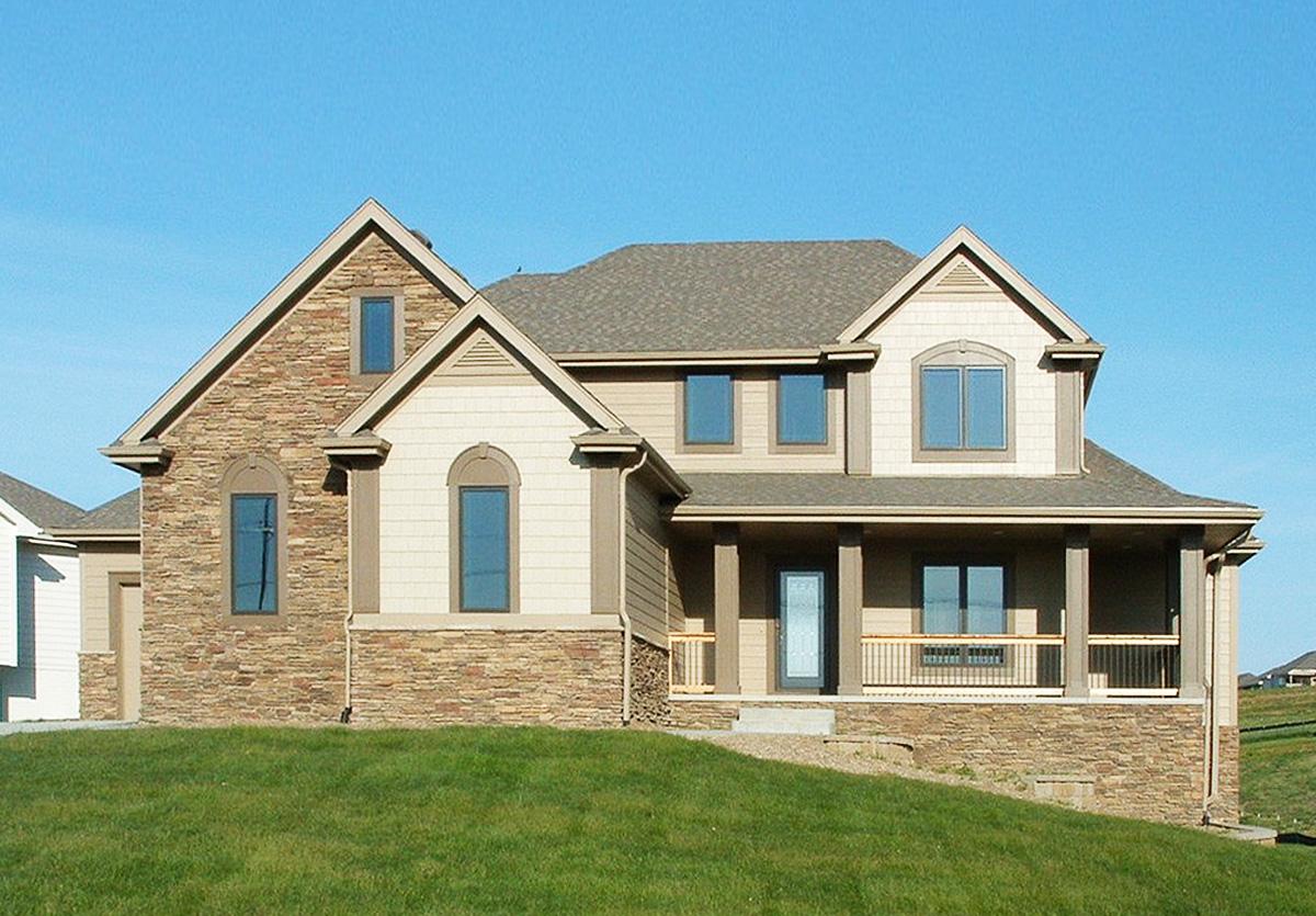 House plan exterior: Two-story home with stone accents, gabled dormers, and a covered front porch with pillars.