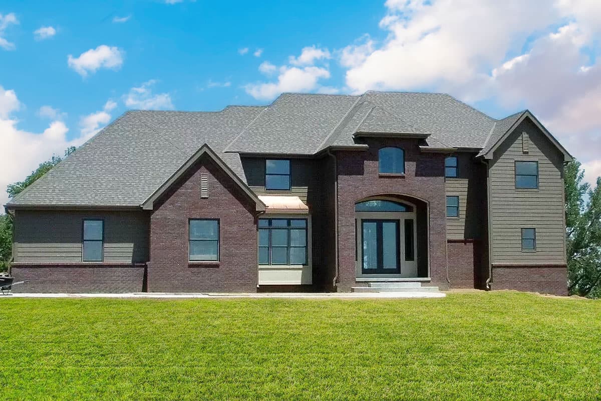 House plan exterior of a two-story home with brick and vinyl siding, prominent gables, and a central arched entryway.