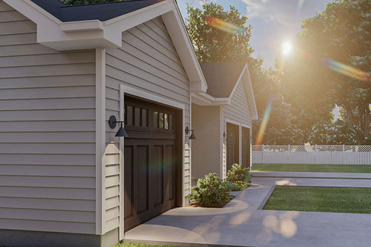 House plan exterior with two garage doors, vinyl siding, gabled roofs, and exterior lighting.
