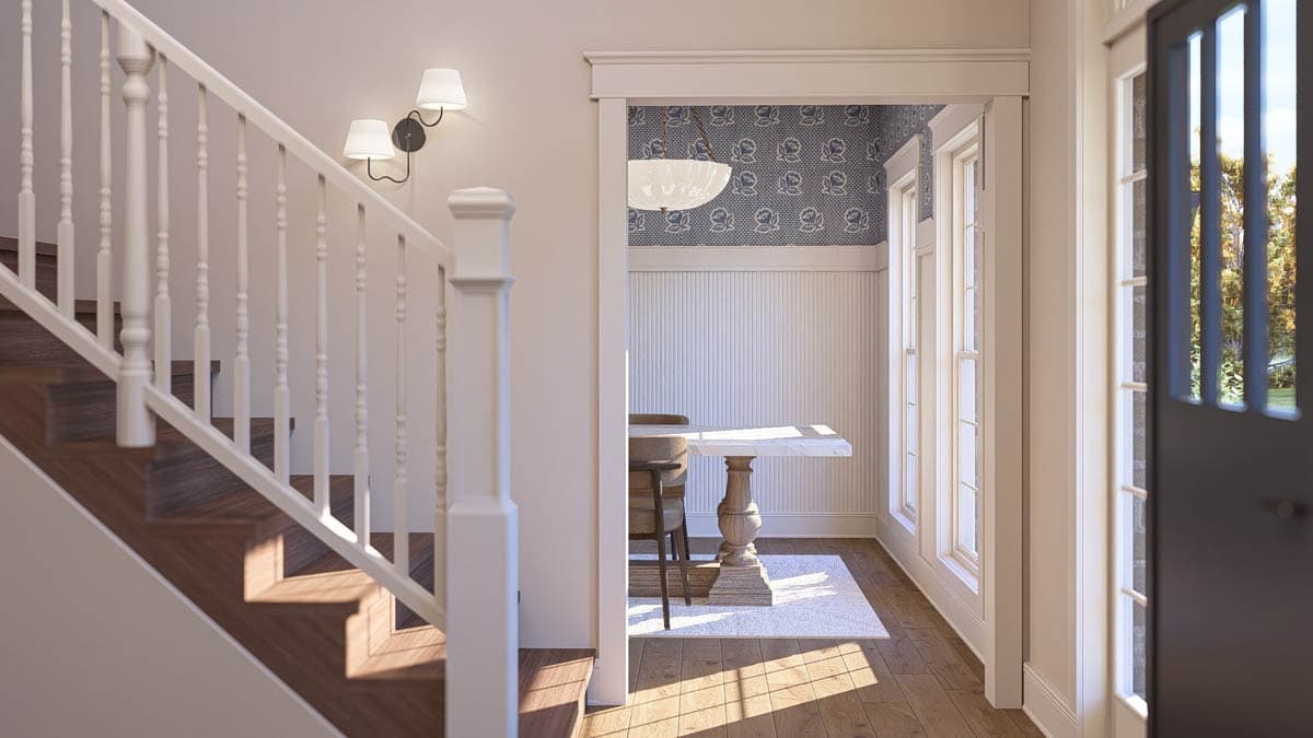 Interior view showing a staircase with white balusters, a small dining area with a marble-top table, and a paneled door.