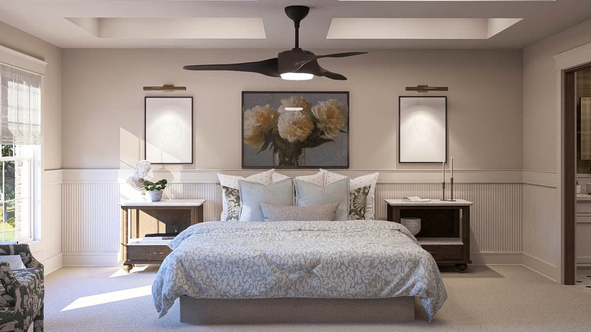 Primary bedroom with tray ceiling, ceiling fan, bed with decorative pillows, two nightstands, and artwork.