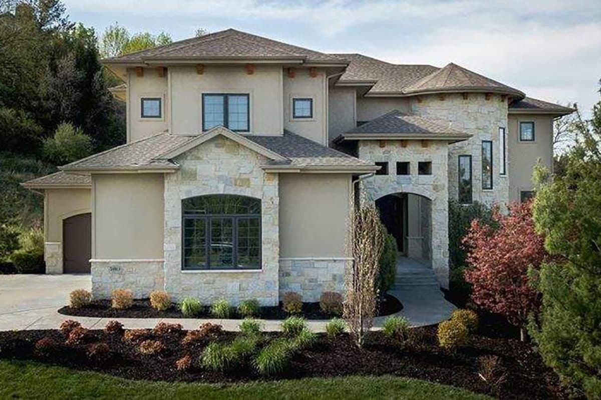 House plan exterior of a two-story home with stucco and stone facade, arched entryway, and multi-level rooflines.