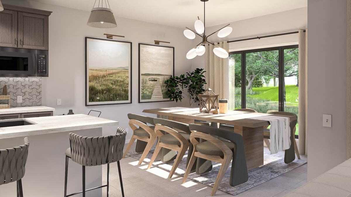 Dining area with wooden table and chairs next to a kitchen with island and bar stools, large windows reveal exterior landscape.