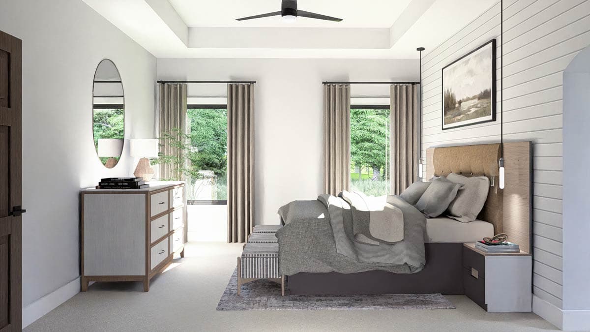 Primary bedroom with tray ceiling, two windows, a bed with upholstered headboard, dresser, and bench.