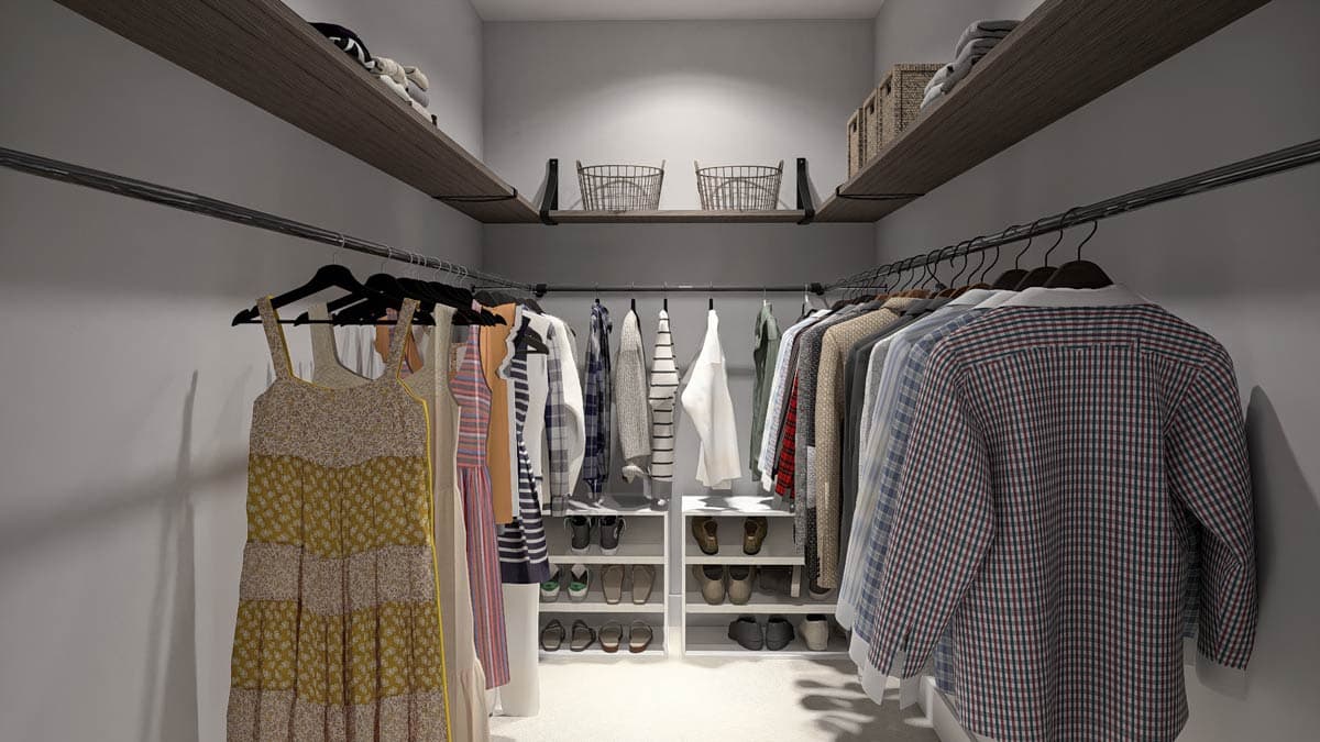 Walk-in closet with tiered shelving, hanging rods, and shoe storage.
