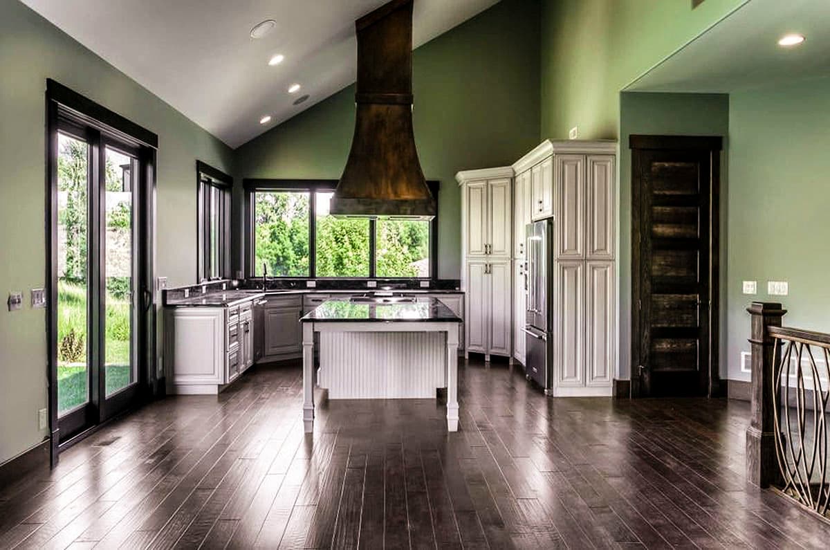 Interior view of a kitchen featuring a large island, vaulted ceiling, and extensive cabinetry.