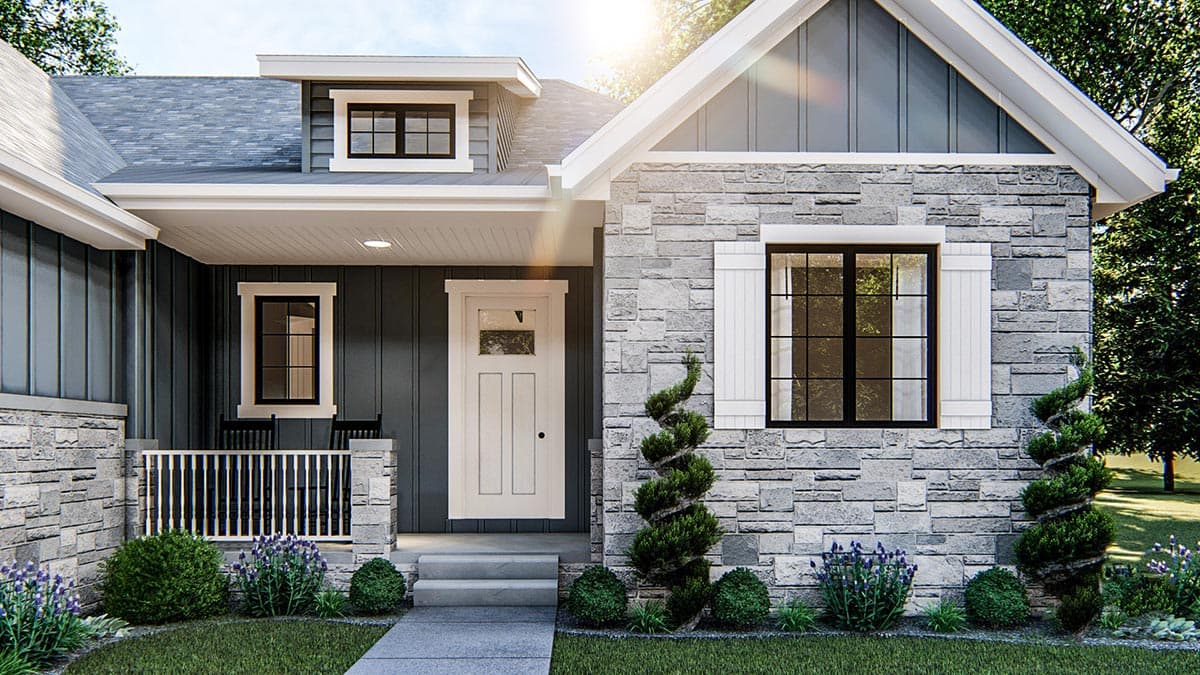 House plan exterior showing stone and vertical siding, covered porch with railing, and a gable dormer with a multi-pane window.