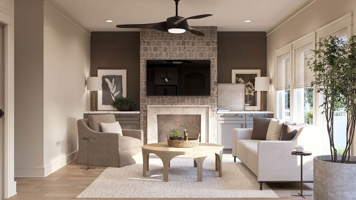 Living room with stone fireplace, television, sofa, armchair, and large windows.