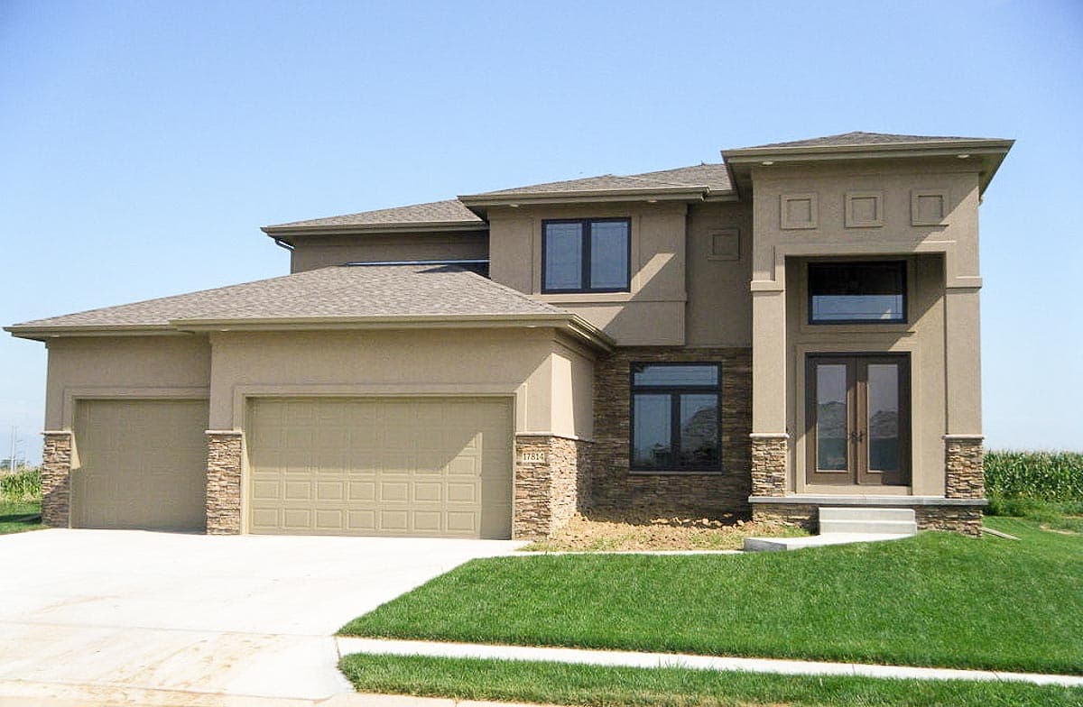 Modern house plan exterior with three-car garage, stone accents, and double-entry doors.