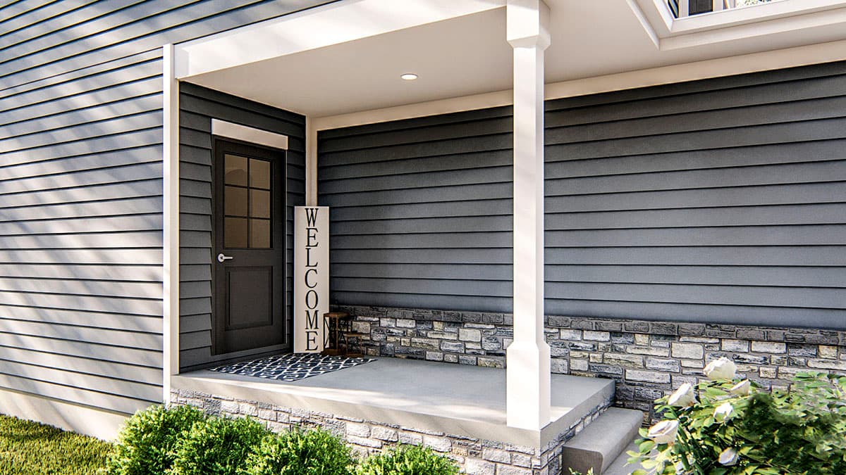 House plan exterior with covered porch, gray horizontal siding, stone wainscoting, and dark front door.
