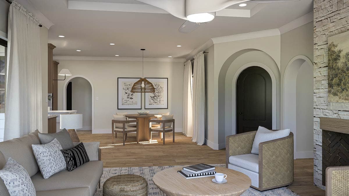 Open concept living area with fireplace, dining nook, kitchen access, and arched doorway.