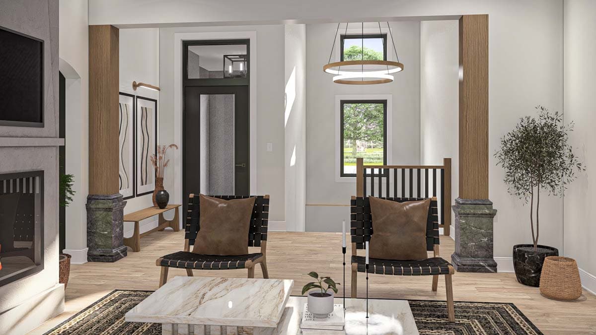 Interior view of a living area with fireplace, two chairs, modern chandelier, wood columns, and large windows.