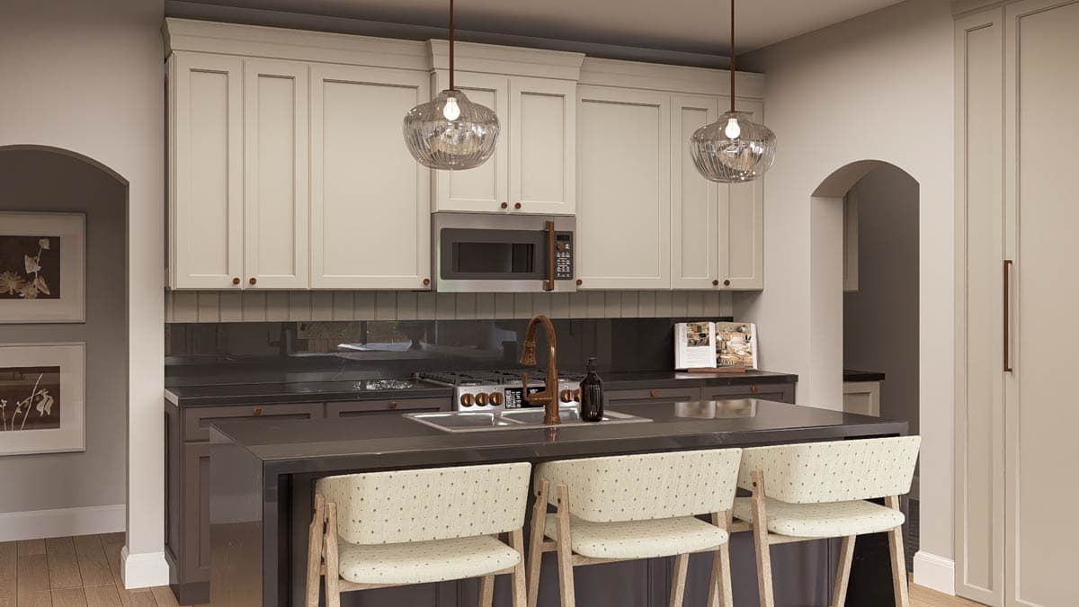 Kitchen interior with light gray cabinetry, dark countertops, a central island with seating, and stainless steel appliances.