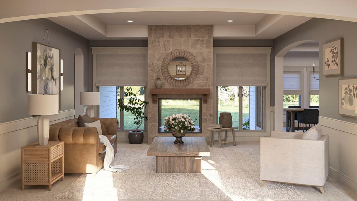 Living room with stone fireplace, tufted leather sofa, wood coffee table, and arched doorway to dining area.