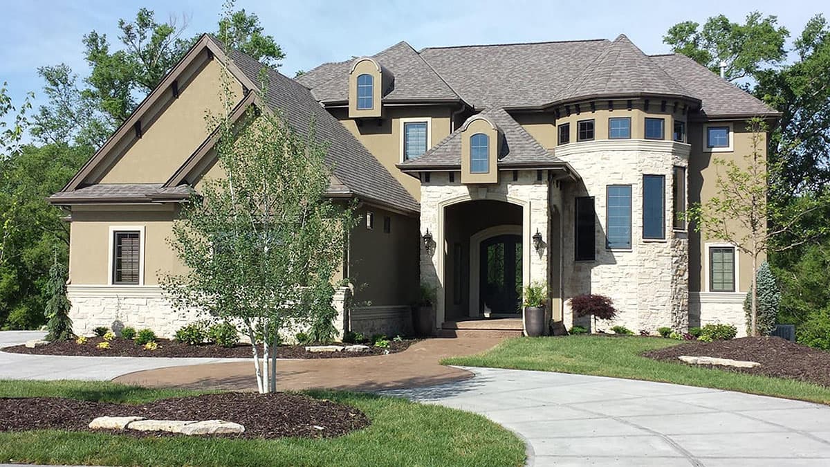House plan exterior: Two-story home with stucco, stone accents, arched entry, and multiple gables and dormers.