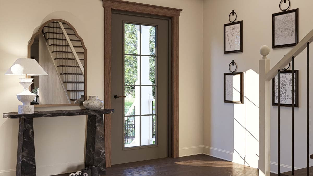 Interior view of a home entryway with a decorative mirror reflecting a staircase, a six-pane glass door, and wall art.