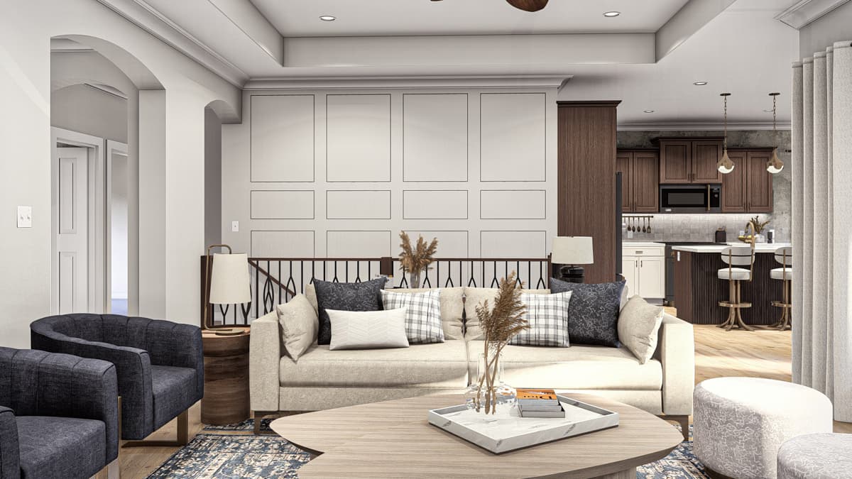 Living room with a fireplace and an open-concept kitchen with a central island, featuring paneled walls and vaulted ceilings.