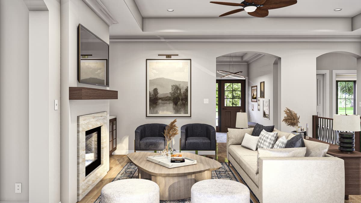 Living room with fireplace, vaulted ceiling, seating area, and view to entryway with double doors.