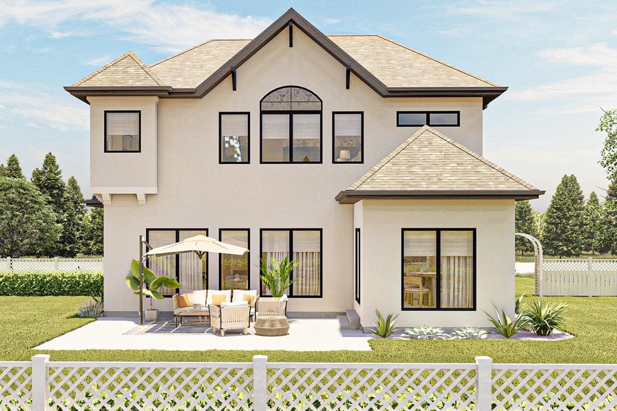 House plan exterior: two-story residence with stucco finish, multiple gables, arched window, and patio with furniture.