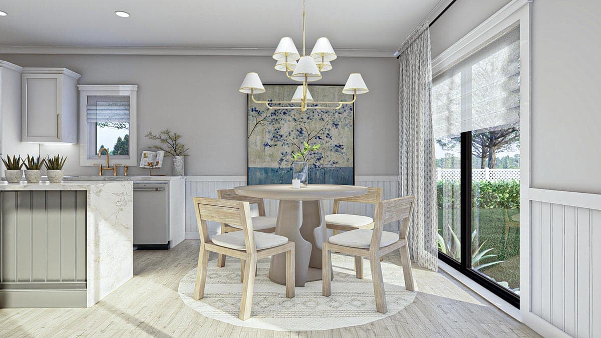 Dining area with round table, four chairs, and large window with view of backyard.