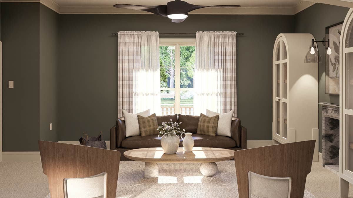 Living room with brown leather sofa, oval coffee table, two chairs, and fireplace.