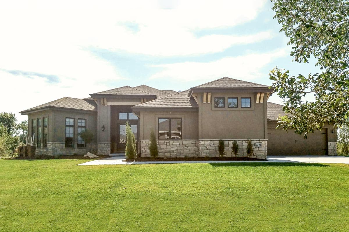Modern house plan exterior with stucco and stone facade, prominent gables, and large windows.