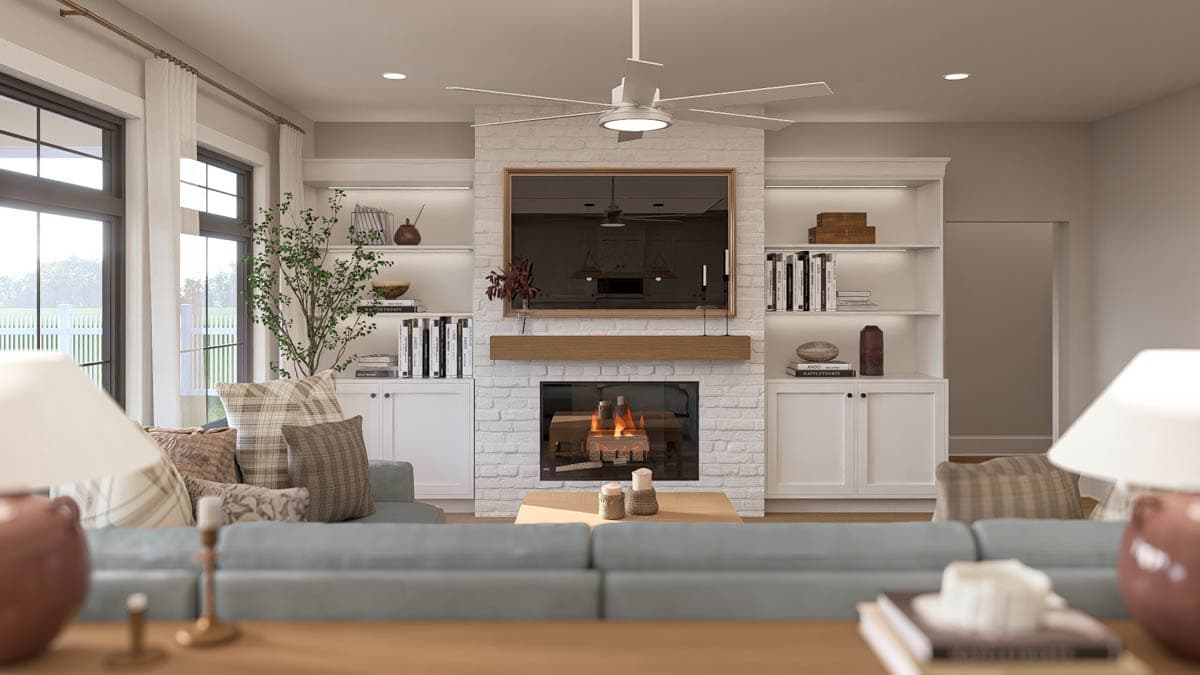 Living room with white brick fireplace, TV, built-in shelves, and large windows. Open layout.