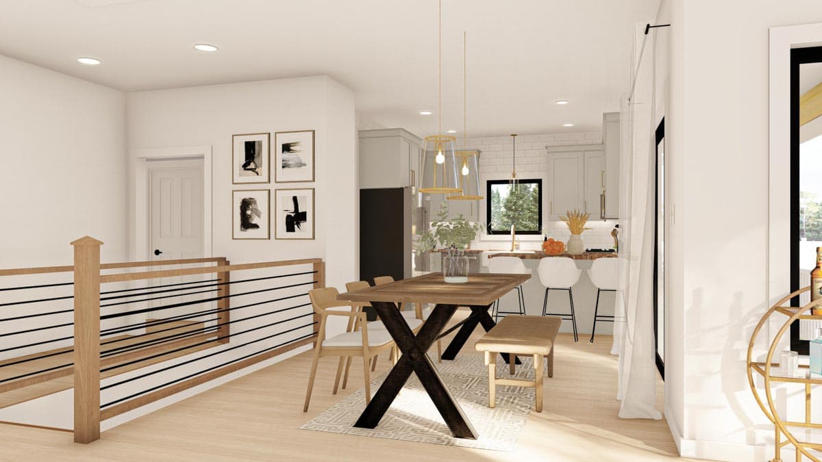 Dining area and kitchen with island, light wood floors, modern railing, and abstract art.