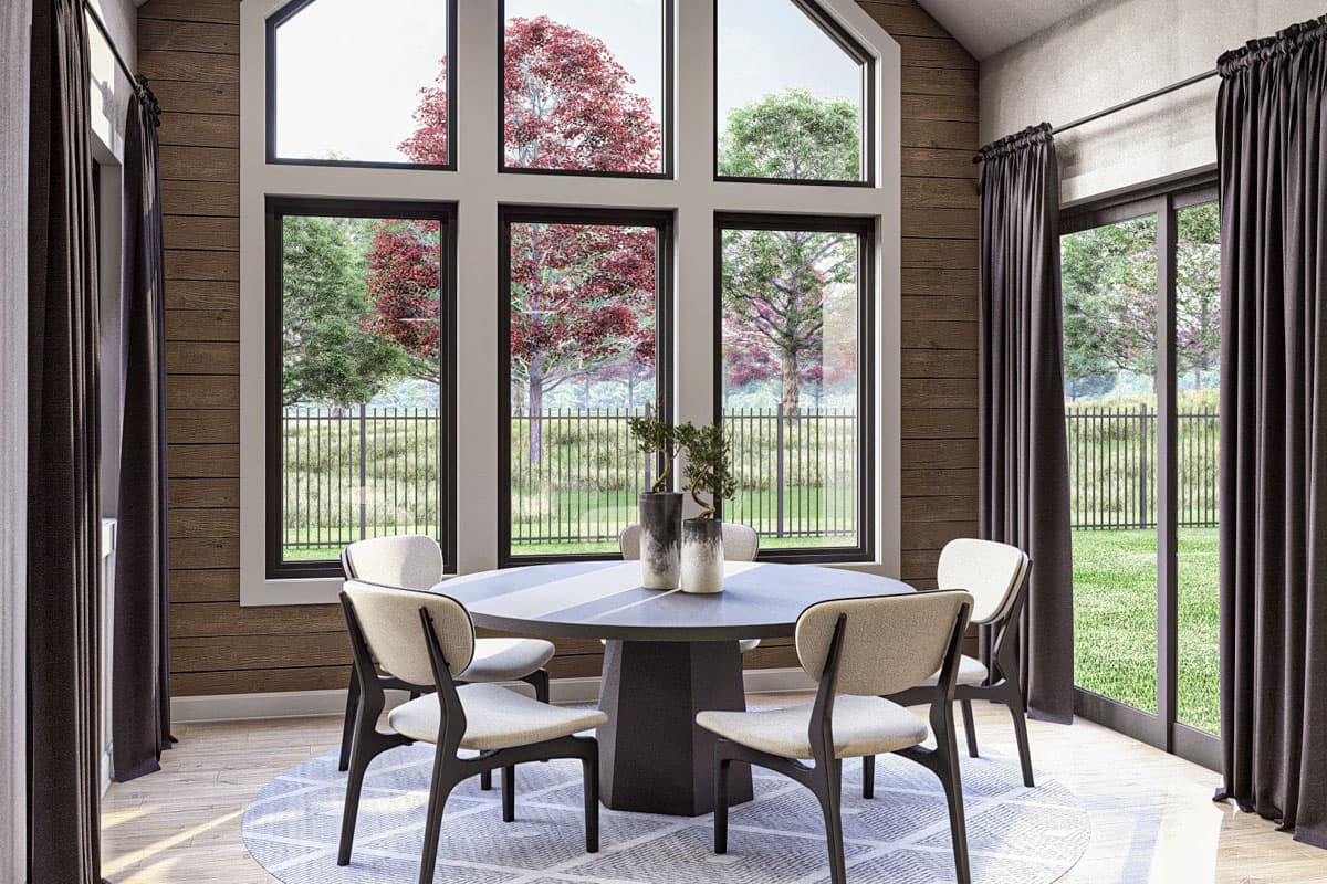 Interior rendering of dining area with round table, chairs, and large window wall overlooking yard.