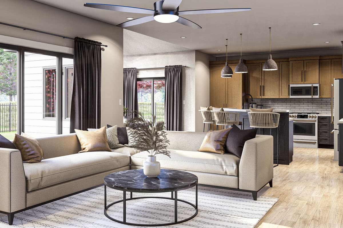 Living room and kitchen open-concept layout with sectional sofa, coffee table, island with bar stools, and modern cabinetry.