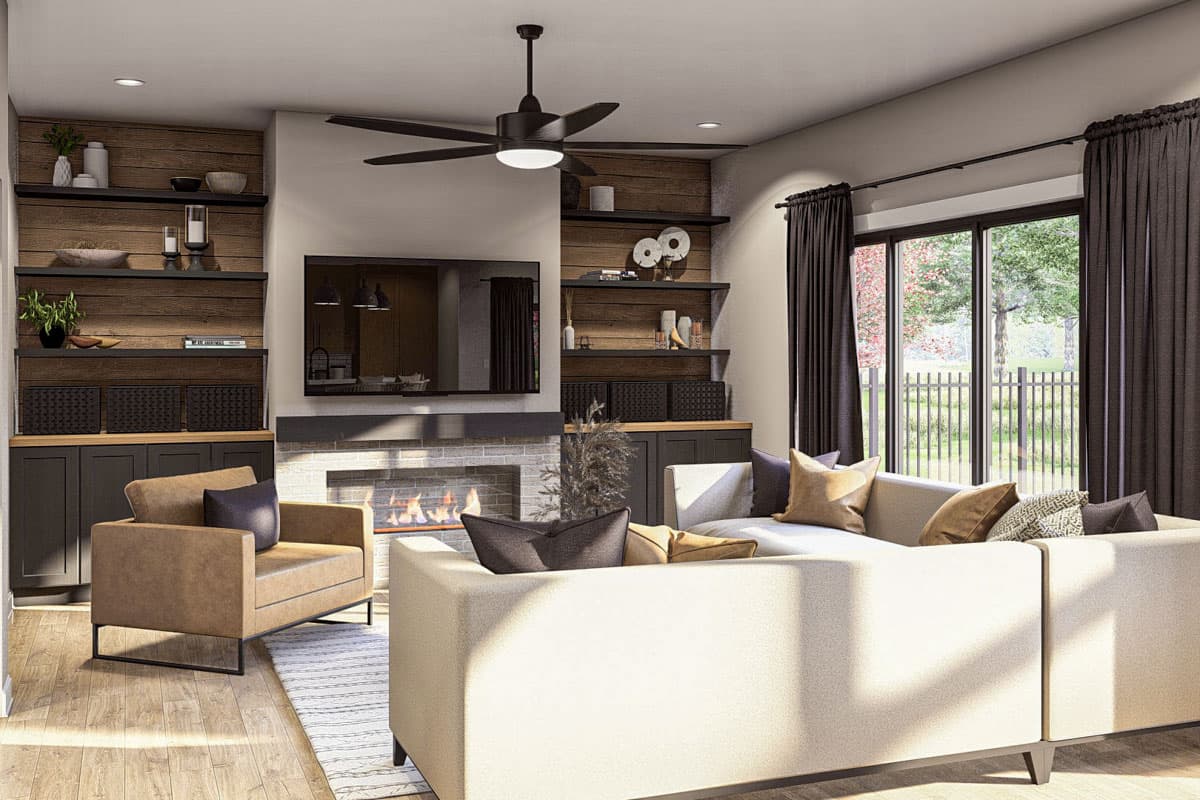 Living room with fireplace, built-in shelving, sectional sofa, and large windows.