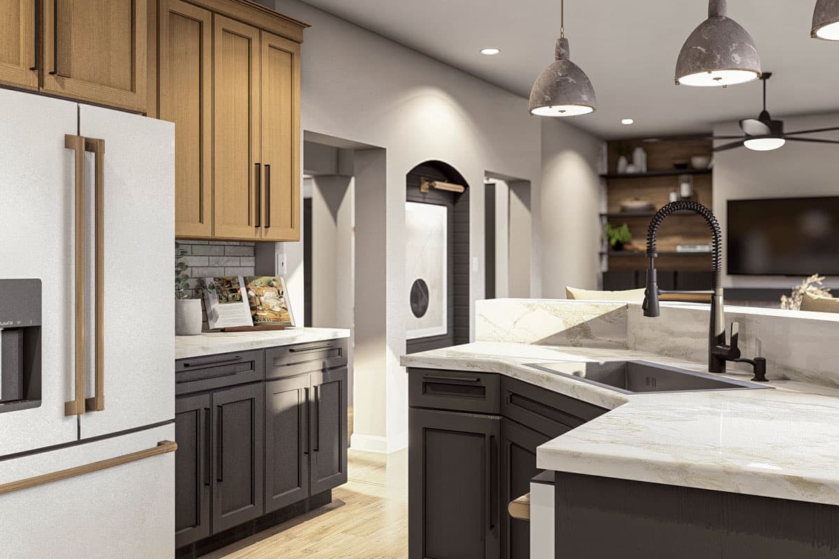 Modern kitchen with two-tone cabinetry, stainless steel refrigerator, granite countertops, and an open layout to the living area.