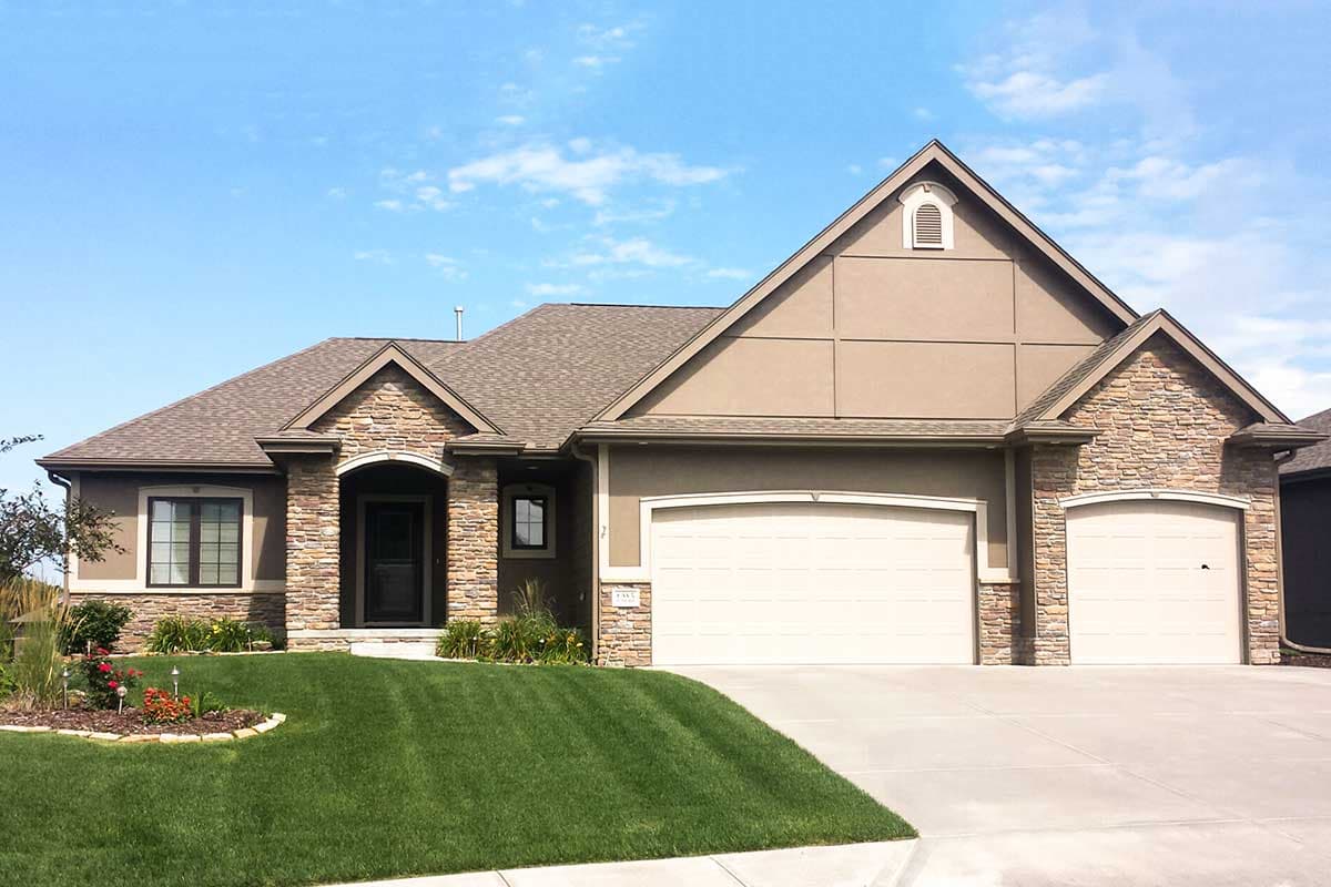 House plan exterior: Ranch style with stone accents, arched entry, and a three-car garage.