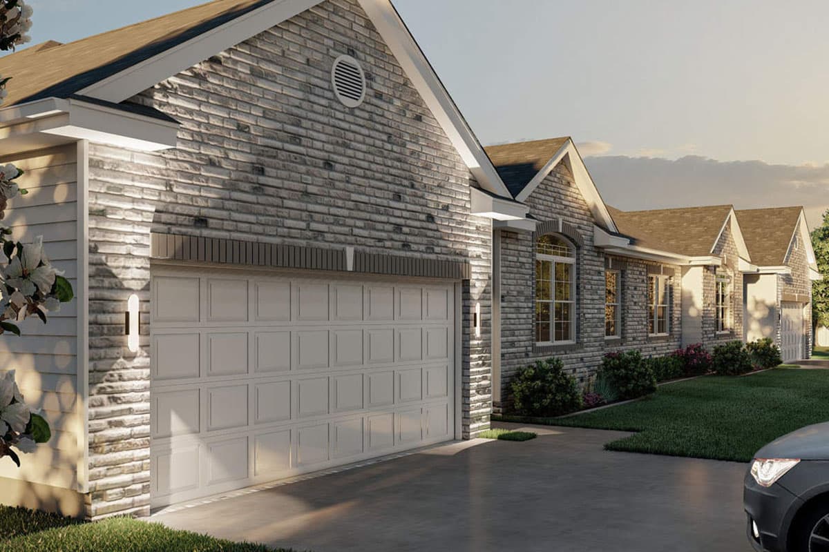 House plan exterior with stone siding, multi-level gables, and a two-car garage.